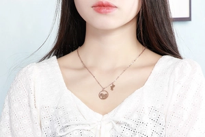 Détail du collier silhouette de chien en or rose avec pendentif os sur un mannequin