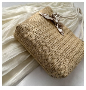 Vue détaillée du tissage d'un sac cabas en paille avec un élégant nœud en ruban