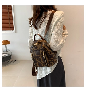 Side view of a vintage mini backpack in brown faux leather with letter print on model