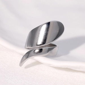 Macro shot of silver irregular spiral ring on warm white textured ceramic background