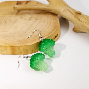 Creative resin broccoli earrings in vibrant green hanging on a decorative wood branch