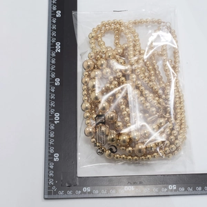 Detail of gold layered pearl body chain with measurement scales in packaging
