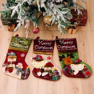 Three large 3D Christmas stockings featuring Santa, Snowman, and Reindeer on wood floor