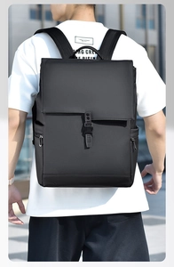 Outdoor view of a man wearing a large black waterproof business backpack with side pockets