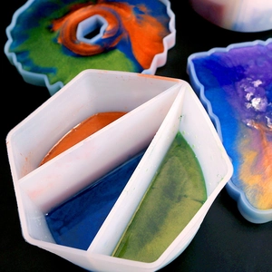 Detail of pouring colorful resin into a multi-slot silicone mixing cup for DIY art