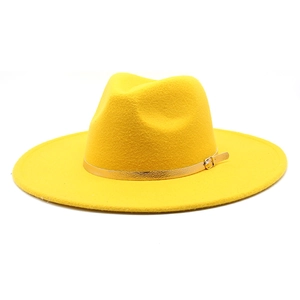 Detail of a bright yellow wide-brim fedora hat with a gold metal buckle belt decoration