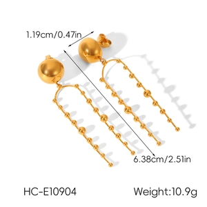 Detail view of gold stainless steel ball earrings with U-shaped beaded long tassels
