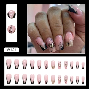 Detail view of pink press-on nails with black V-shaped French tips and gold glitter lines