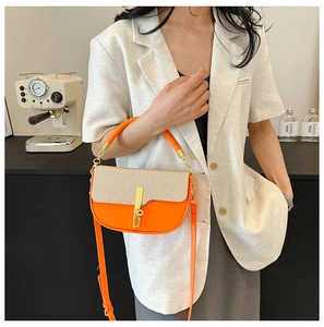 Detail of orange and beige woven box bag with gold-tone hardware and chain strap