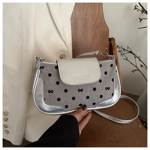Détail du motif à pois et du nœud sur le sac sous le bras argenté contrasté