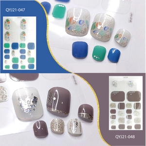 Detail of glitter toenail wraps in blue and brown with artistic shimmer wave patterns
