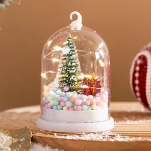 Close-up of a Christmas snow globe with LED lights, mini tree, and colorful foam beads