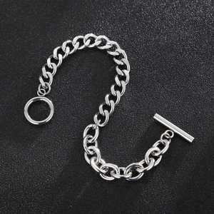 Bracelet en acier titane argenté avec maille cubaine et fermoir T sur fond noir texturé