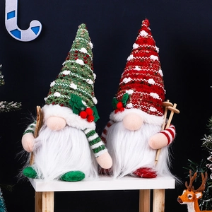 Detail of Christmas gnomes with knitting hats and wooden ski poles on white shelf