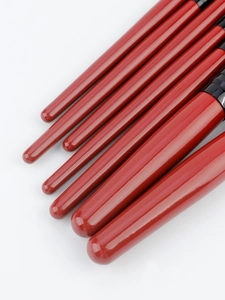 Detail of red wood handles and black metal ferrules on a professional makeup brush set