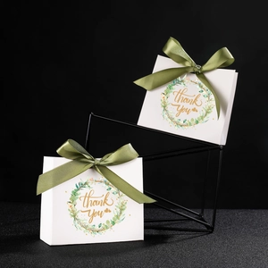 Detail of white wedding gift box with green ribbon and golden Thank You wreath print