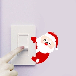 Close-up of Santa Claus wall sticker peaking behind a white light switch panel