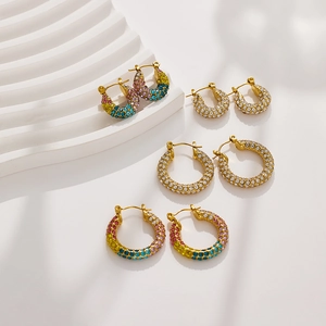 Set of luxury stainless steel hoop earrings with colorful crystals on marble base