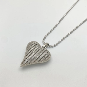 Macro shot of silver heart pendant with pave cubic zirconia on a bead chain necklace