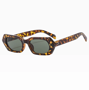 Detail view of tortoiseshell polygon frame sunglasses with dark green protective lenses