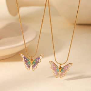 Close-up of golden snake chain necklaces with colorful enamel butterfly pendants