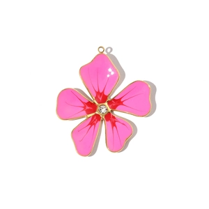 Detail of pink enamel flower pendant with crystal center and golden stainless steel frame