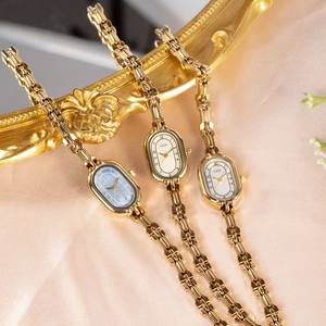 Elegant vintage GEDI gold watches with oval dials on luxury pink silk background
