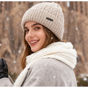 Winter set with beige cable knit hat and white scarf shown against a snowy background