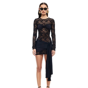 Detail of black lace mini dress showing asymmetric pleats and long sleeve texture