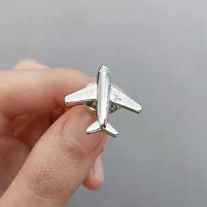 Minimalist silver airplane shaped alloy brooch pin with polished metal texture finish