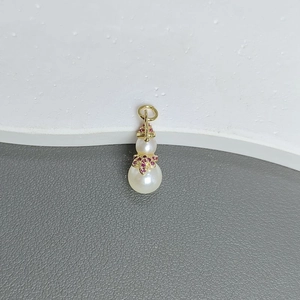 Detailed view of gourd-shaped pendant with white pearls and gold zircon-inlaid accents