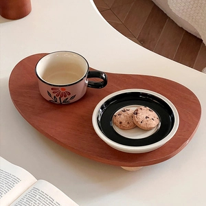 Rustic red-brown wooden tray with floral ceramic cup and cookies for afternoon tea