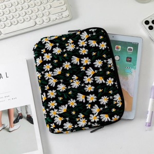 Detail of embroidered daisy laptop sleeve with secure zipper and quilted floral texture