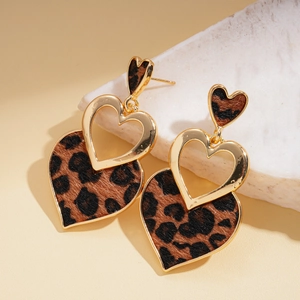 Vintage gold-framed heart earrings with leopard print fur pattern on marble