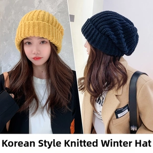 Detail view of yellow and black oversized knitted beanies showing warm slouchy texture