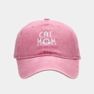 Close-up of pink washed denim baseball cap with CAT MOM white embroidery detail