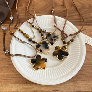 Detailed macro view of resin heart pendants and tiger eye beads on ethnic style necklaces