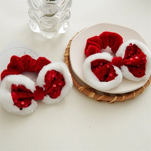 Detailed shot of red velvet Christmas scrunchies with white faux fur trim and red sequins