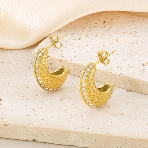 Vue macro détaillée de boucles d'oreilles en or 18 carats en forme de C avec strass et pois