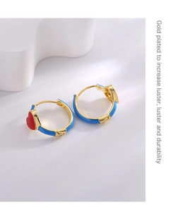 Detail of 18K gold plated heart hoop earrings with blue enamel and red heart patterns