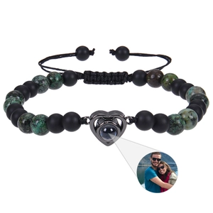Macro shot of custom heart projection bracelet with matte black beads and green stones