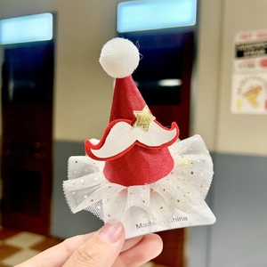 Macro view of Christmas clip with red hat, golden star and white glitter mesh detail