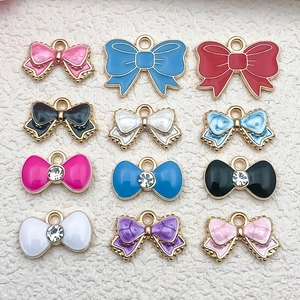 Detailed view of colorful enamel bow charms for DIY jewelry making in assorted styles
