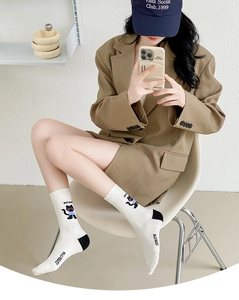Detail of white cotton socks featuring a black cartoon cat pattern and Miao text design