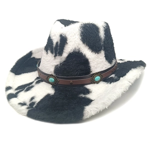 Detail of cow print cowboy hat featuring faux fur texture and turquoise stud band