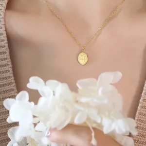 French vintage gold leaf pendant necklace in titanium steel worn by a model