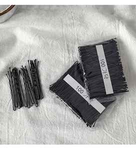 Detailed view of 100pcs black wavy metal hair pins in a clear package for hair styling