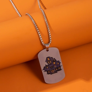 Close-up of stainless steel dog tag necklace with purple haunted house on orange background