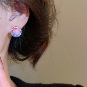 Detail of flower stud earrings featuring pink beads, blue accents and cubic zirconia