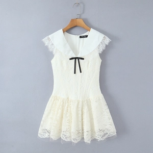 Detail of French lace dress with navy collar and black bow accent on white mesh fabric